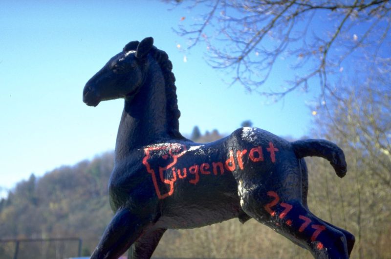 Holbein-Pferd schwarz mit roter Schrift „Jugendrat“ vor blauem Himmel