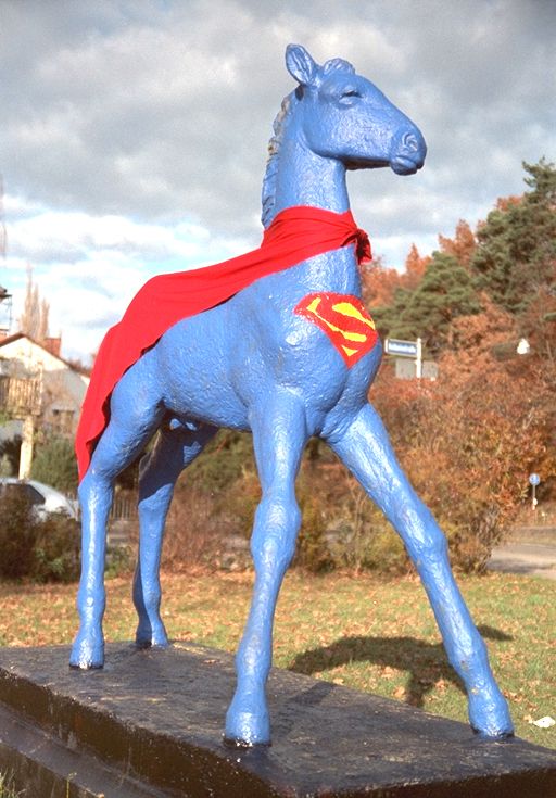 Holbein-Pferd hellblau mit rotem Umhang und Superman-Logo als Super-Pferd