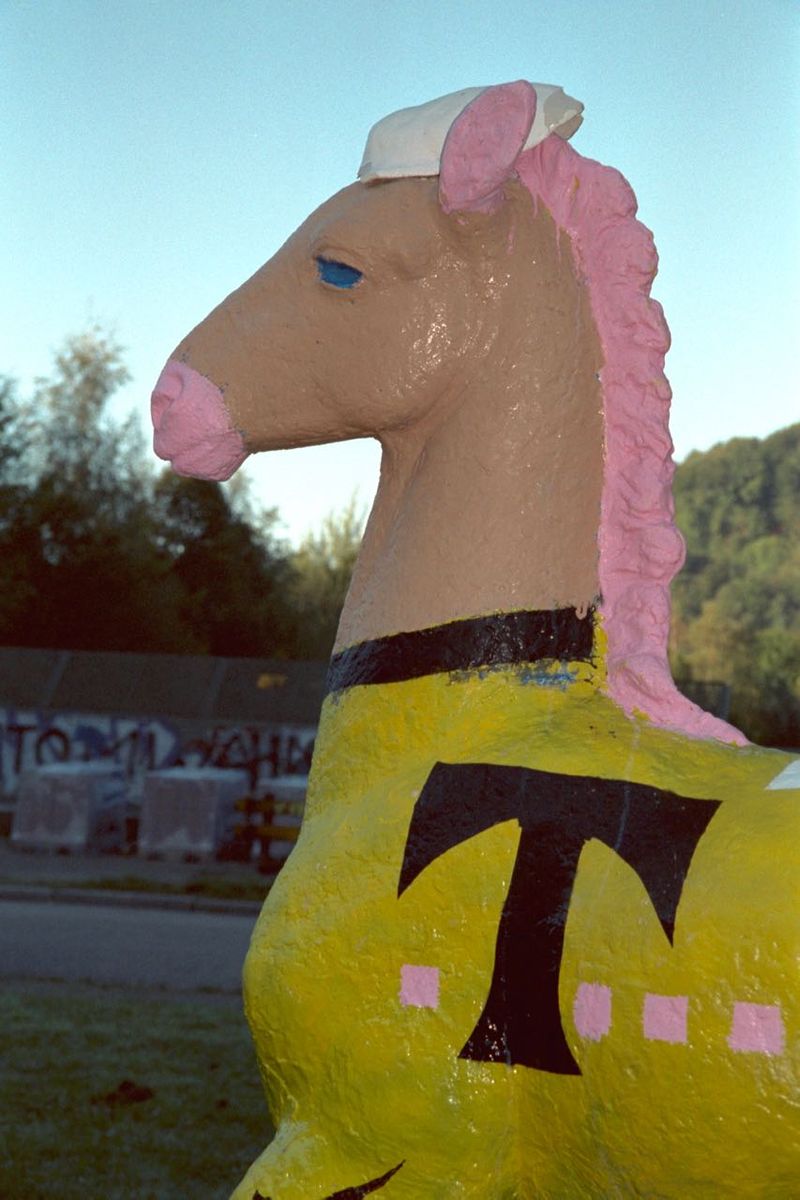 Holbein-Pferd Nahaufnahme: Kopf mit rosa Mähne, gelber Körper mit „T“ der Telekom