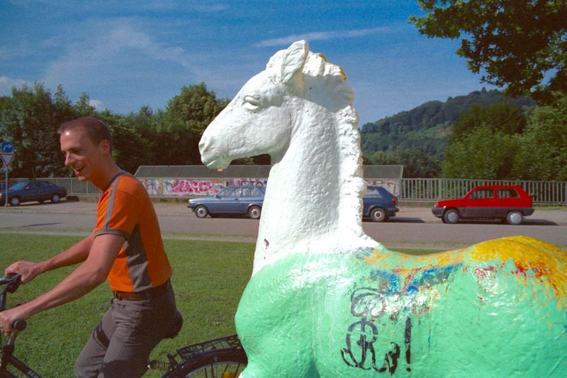 Holbein-Pferd Radfahrer vor dem weiß-grün bemalten Pferd bei Dreharbeiten für „Traumland Deutschland“